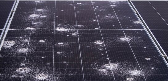 Schade aan je zonnepanelen na storm of hagel Zonnepanelen met zichtbare hagelschade en impactpunten na een storm.