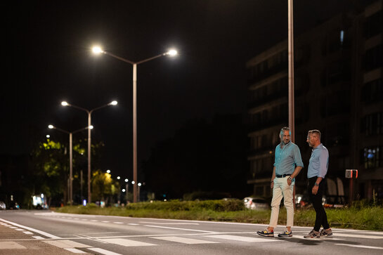 Twee wandelaars in een verlichte straat