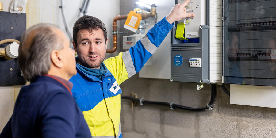 Vanaf 2026 plaatst Fluvius enkel nog driefasige elektriciteitsmeters Technieker van Fluvius geeft uitleg een een klant