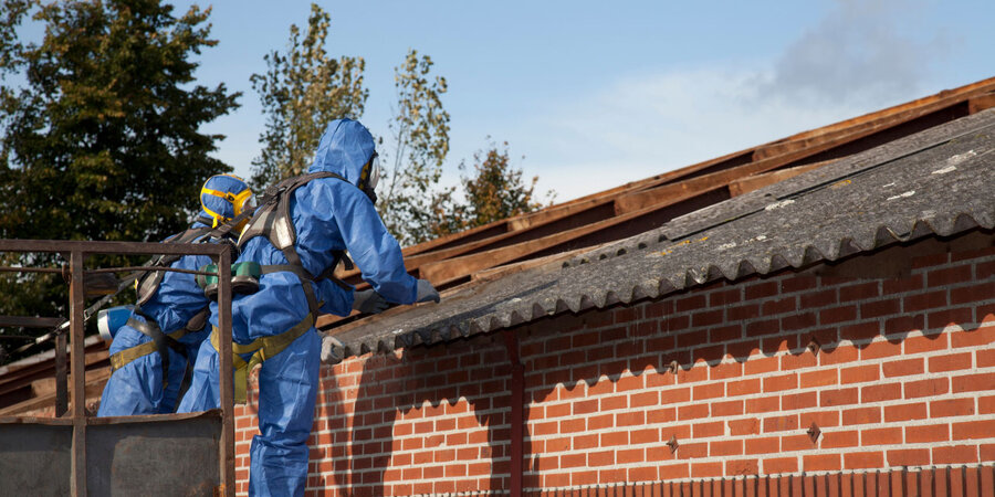 Verwijdering van een asbesthoudend dak op een niet-verwarmd gebouw ter voorbereiding van dakvernieuwing.