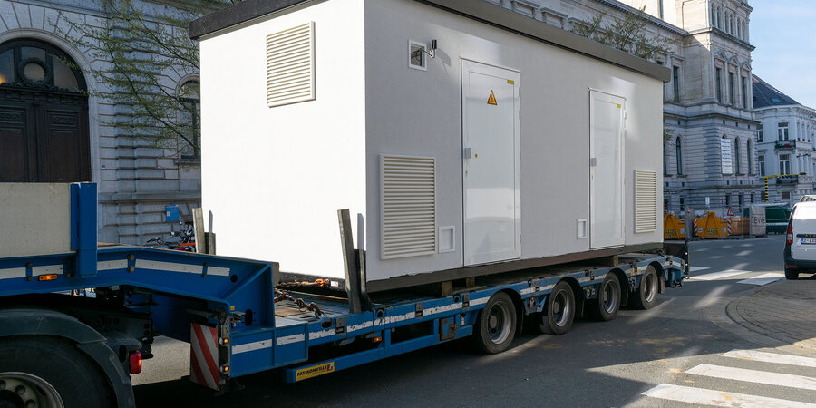 Verplaatsbare hoogspanningscabine wordt per vrachtwagen vervoerd naar een aansluitlocatie.