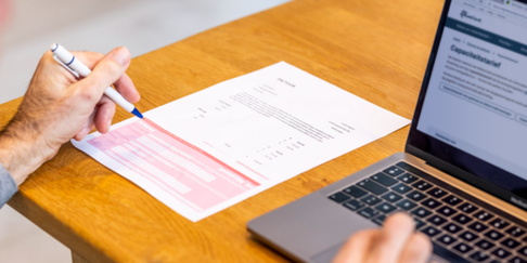 Persoon aan de pc met overschrijvingsformulier