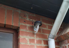 Een externe antenne, voor een bekabelde digitale meter, geplaatst tegen de gevel van een huis 